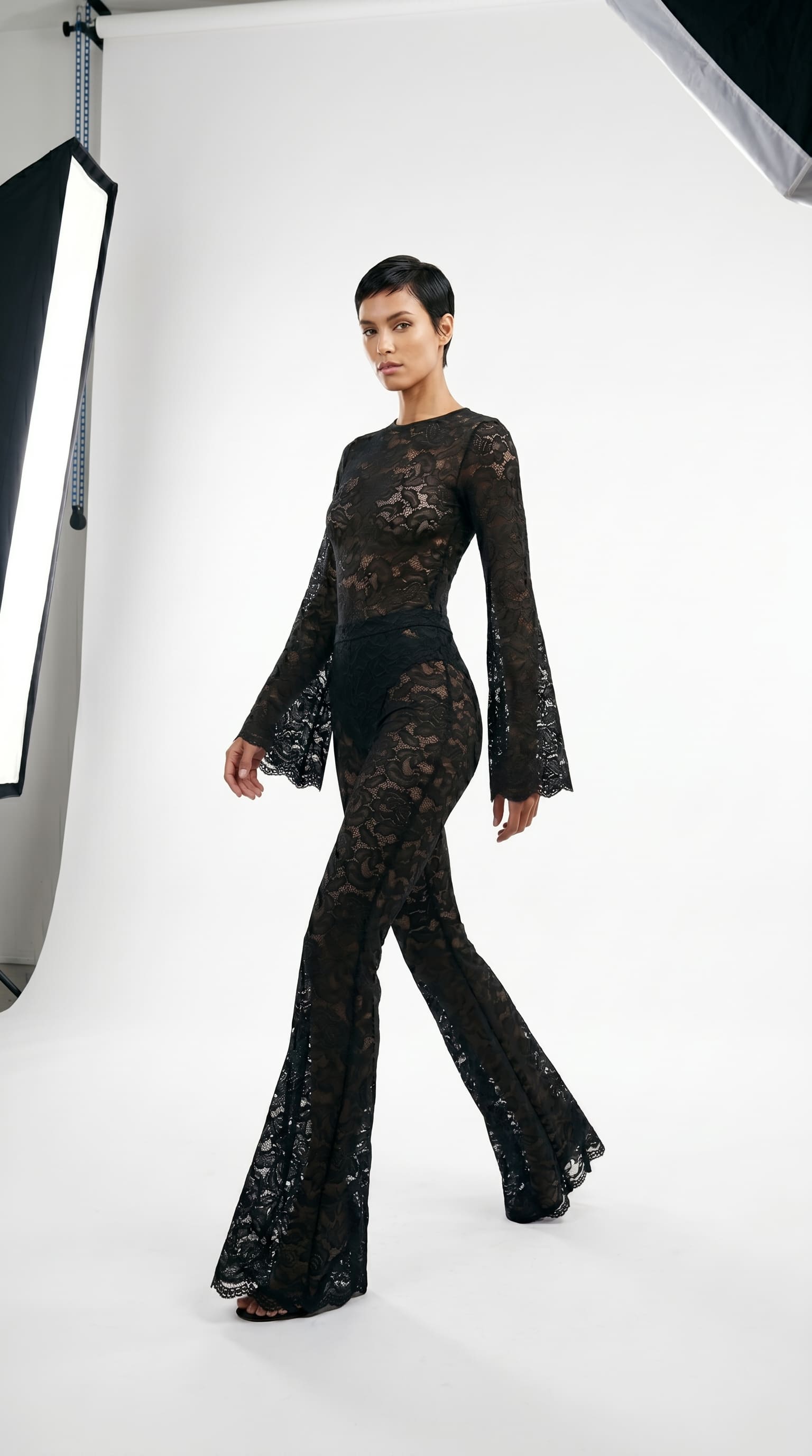 Detailed view of artisanal stretch lace embroidery on the black suit.