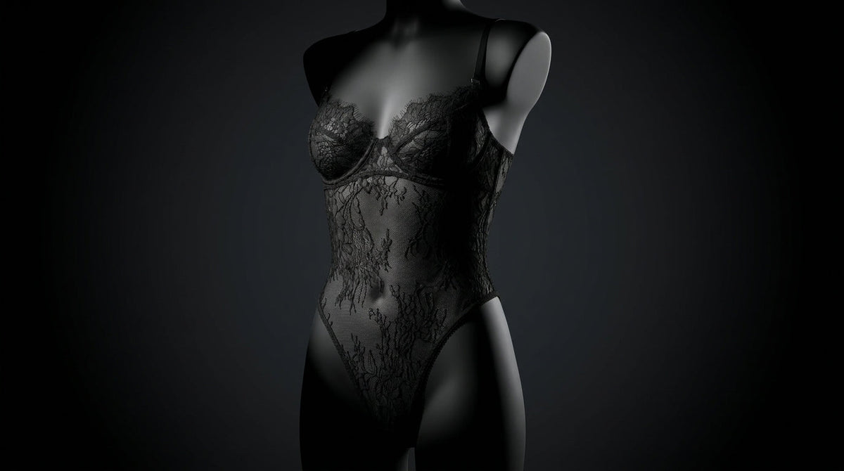 Three-quarter view of a black lace bodysuit's architectural strap structure against a dark backdrop