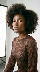 Detailed view of artisanal stretch lace embroidery on the brown suit.