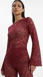 Detailed view of artisanal stretch lace embroidery on the red suit.