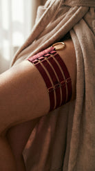 Handcrafted red leg accessory with gold-plated rings and quadruple straps.