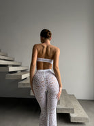 Bespoke white Goddess Aura lace suit with flared pants and bandeau top.