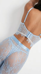 Detailed close-up of the delicate blue lace patterns and stitching on pants