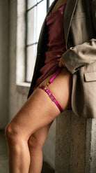 Detailed view of artisanal pink elastic leg garter for a custom fit.