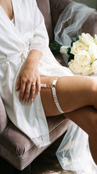 Detailed view of artisanal white elastic leg garter for a custom fit.