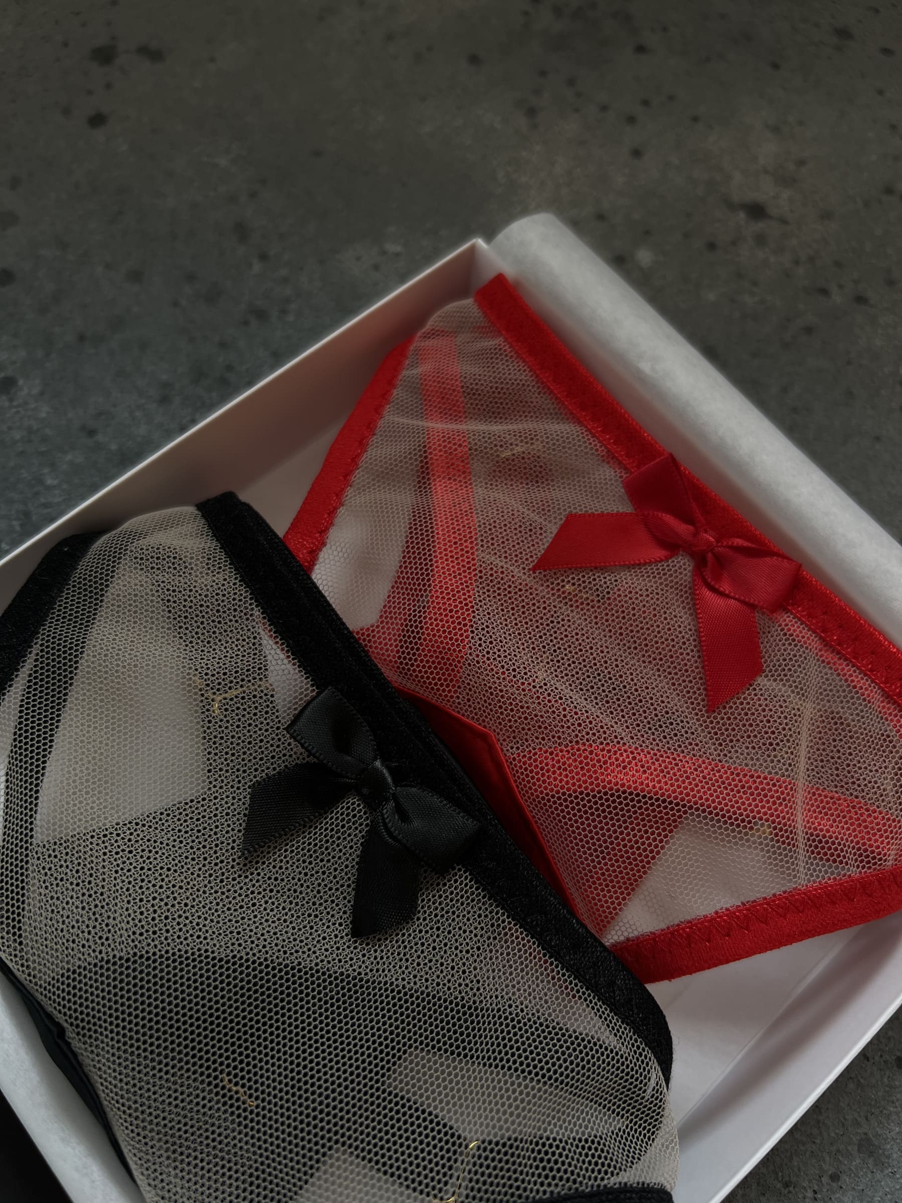 Close-up of the handcrafted Provocation mesh panties showing intricate strappy details and gold adjusters designed for a provocative second-skin silhouette.