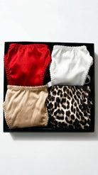 Artisanal multicolor Silk Box set featuring four handcrafted panties in red, white, beige, and leopard print.