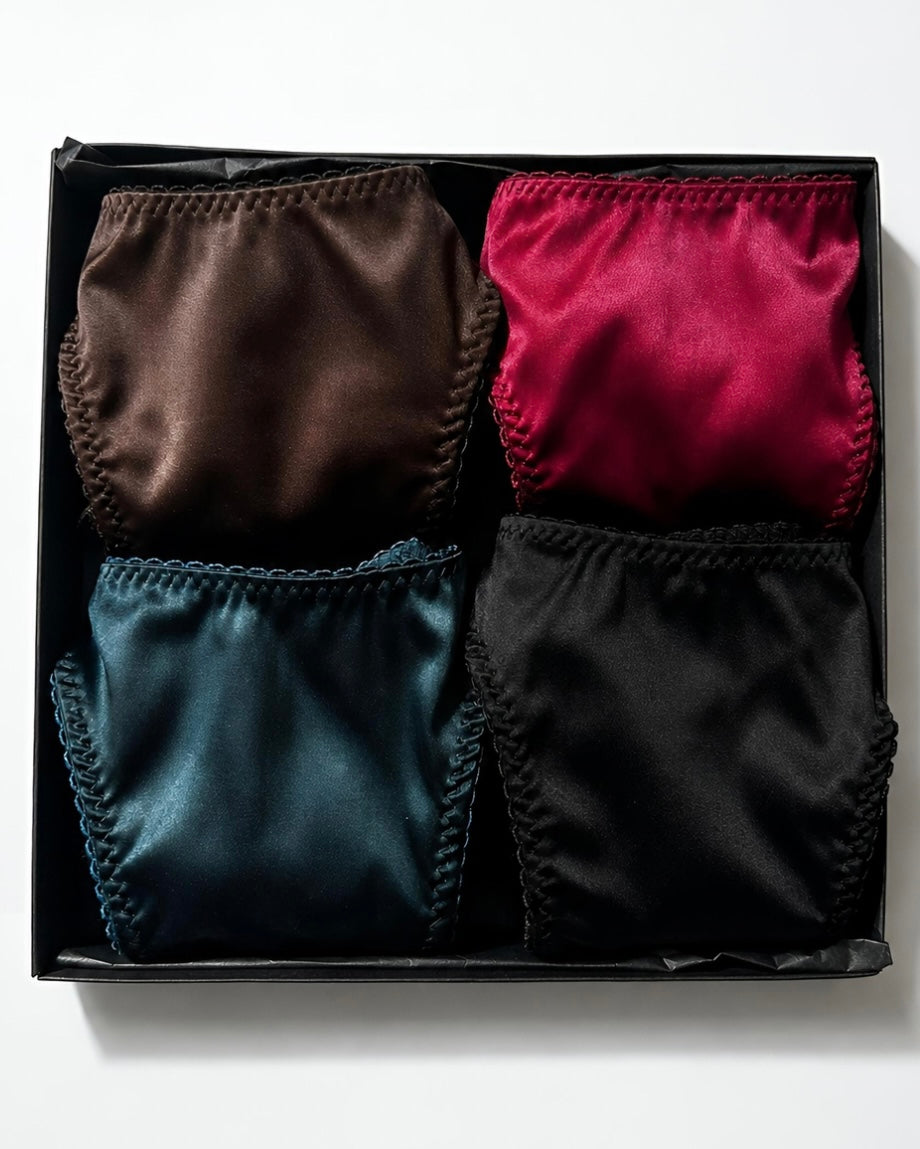 Artisanal multicolor Silk Box set featuring four handcrafted panties in brown, bordeaux, emerald, and black tones.