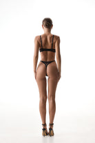 Sculptural black lingerie set Provocation with geometric straps and sheer mesh.
